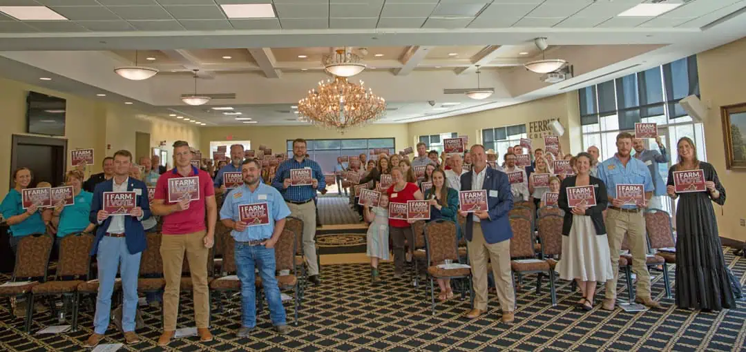 Virginia Farm Bureau Federation Summer Expo attendees display I Farm I Vote signs in the Blue Ridge Mountain Room at Ferrum College
