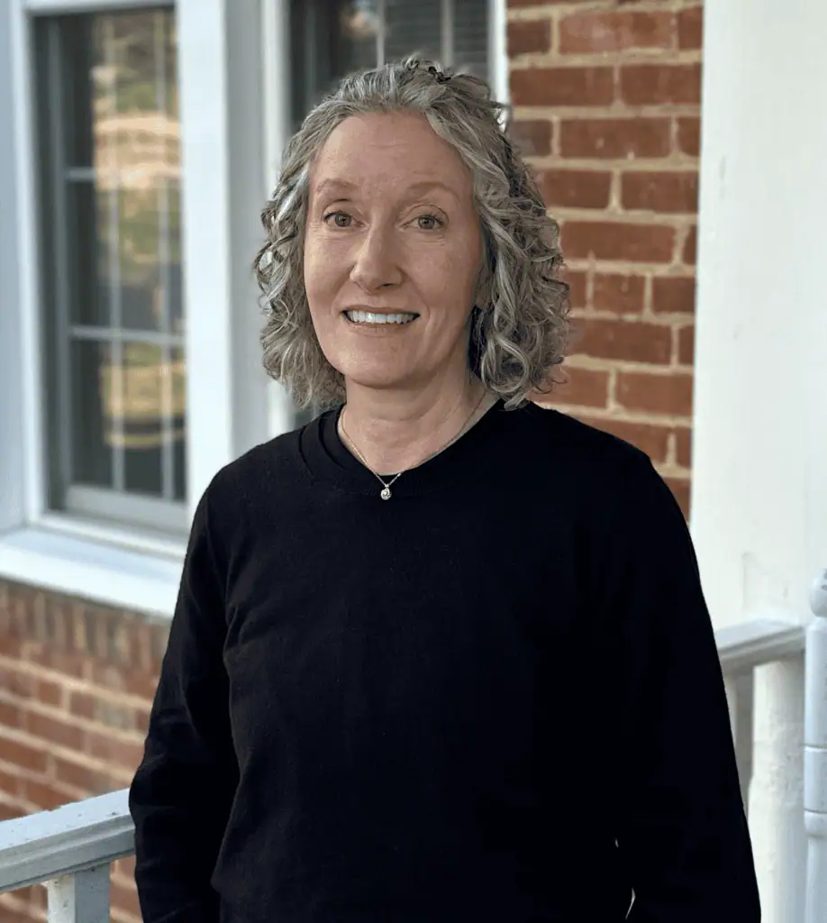 Headshot of Lori Sliwa on the front porch of John Wesley Hall
