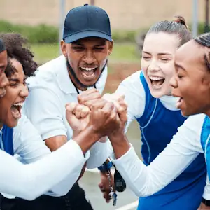 A group of people standing in a circle holding hands and celebrating.