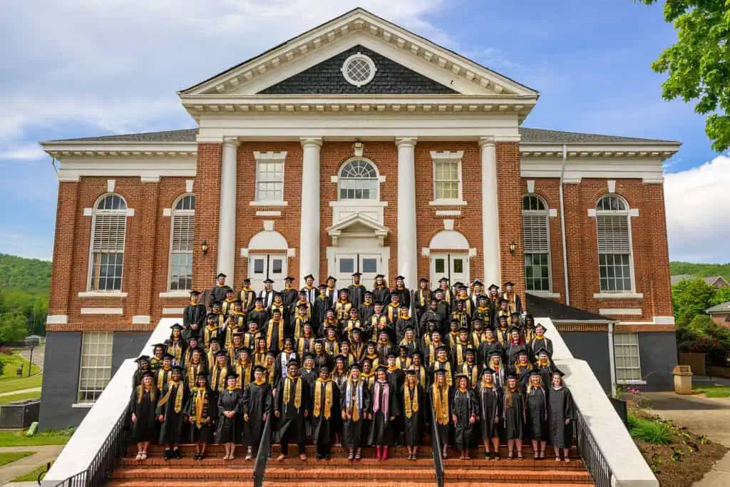 The Ferrum College Class of 2025 in full regalia on the steps of Schoolfield Hall