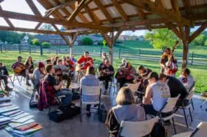 People sit around in chairs and play music and sing songs