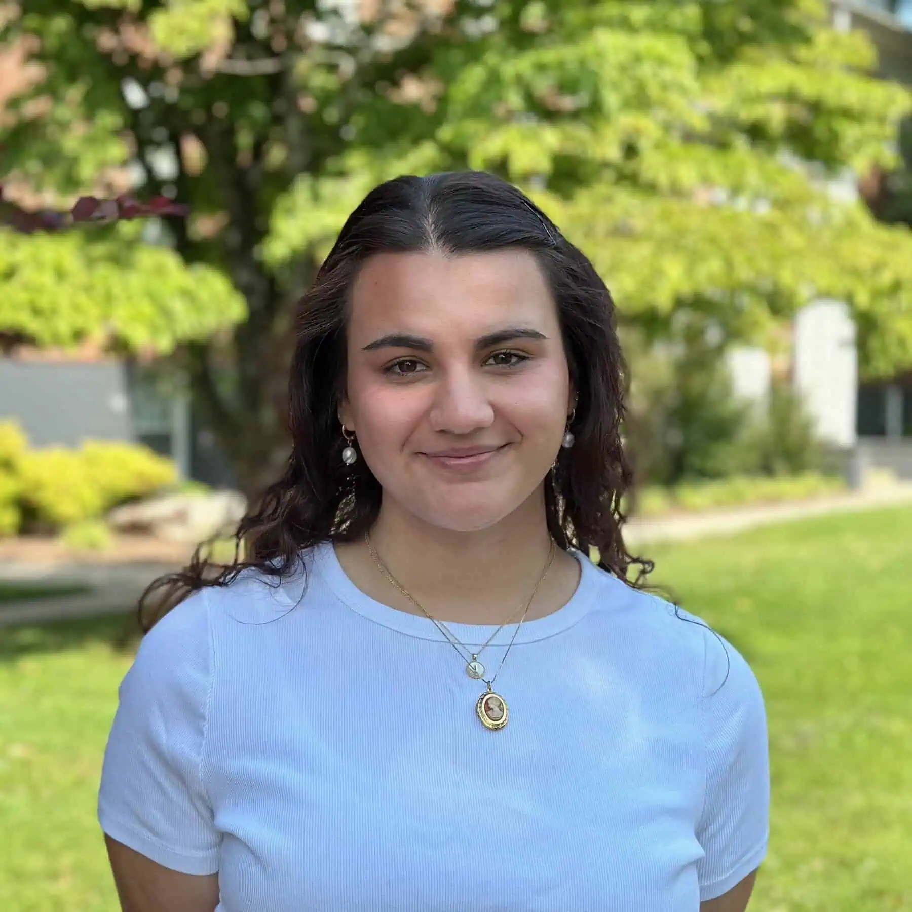 The photo is of Admissions Events & Visit Coordinator Emily Walker taken outside on campus on a pretty summer day