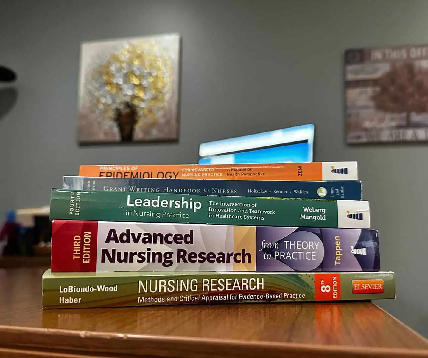 Stack of books used in the MSN program at Ferrum College on a desk