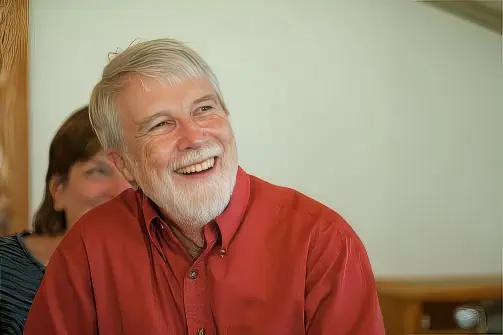 Ferrum College Professor Emeritus Pete Crow is smiling and wearing a red shirt