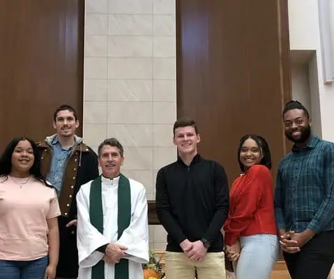 students on an e-term with a priest