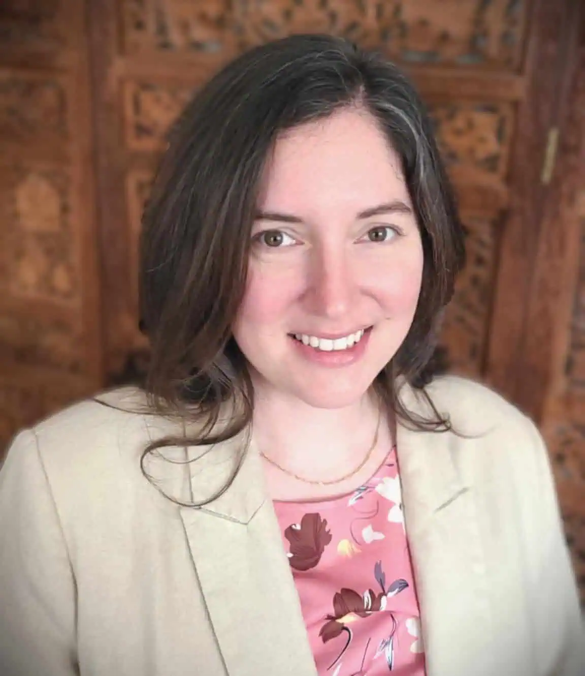 headshot of Assistant Professor of Teacher Education and Program Support Specialist Sara Evers who is wearing a cream colored blazer over a floral blouse